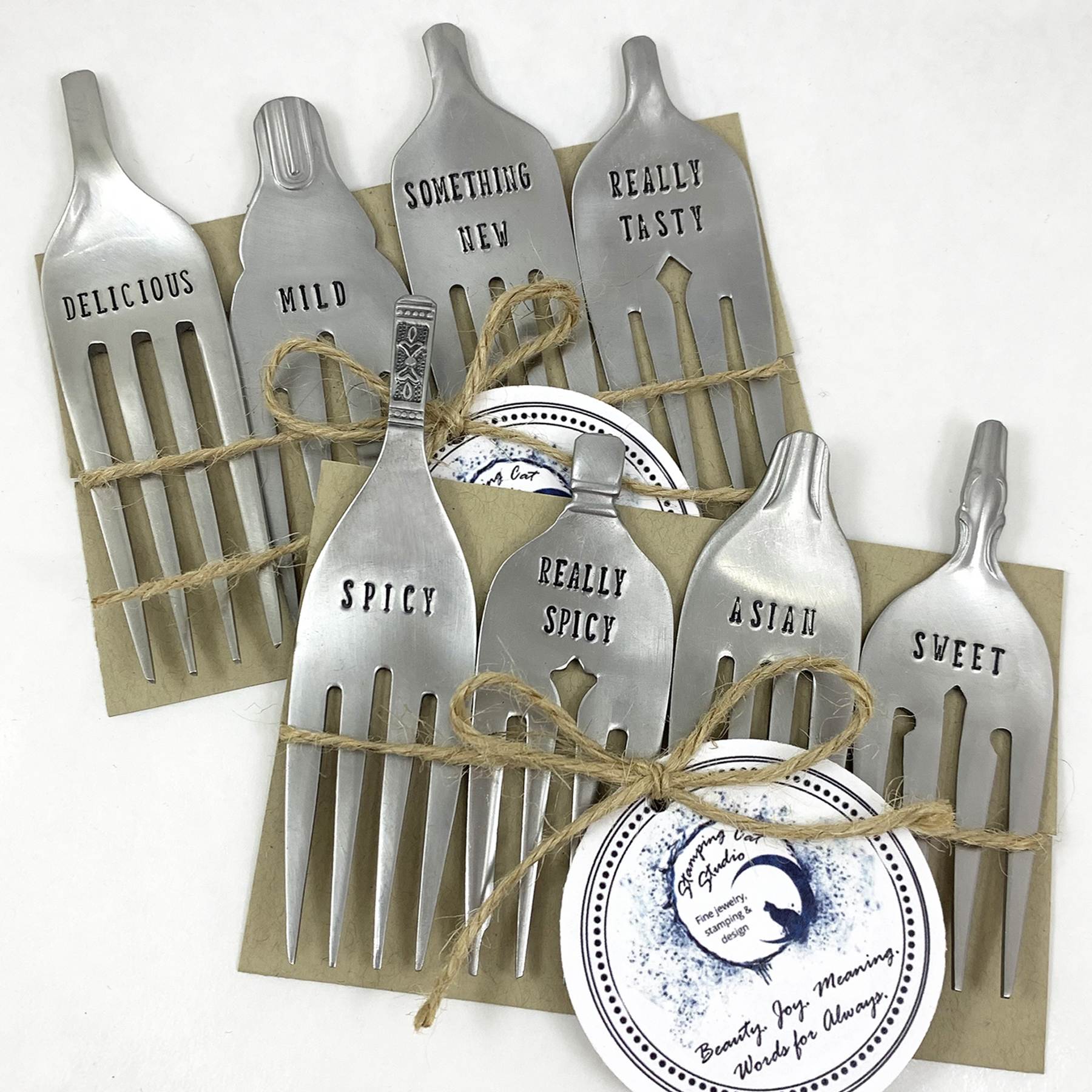 Charming Custom Cheese Marker Forks feature flattened, stamped tines with labels like “DELICIOUS” and “MILD.” Tied with twine on brown cards, they’re a fun way to label cheeses for any tasting spread. Read more at Stamping Cat Studio (stampingcatstudio.com).
