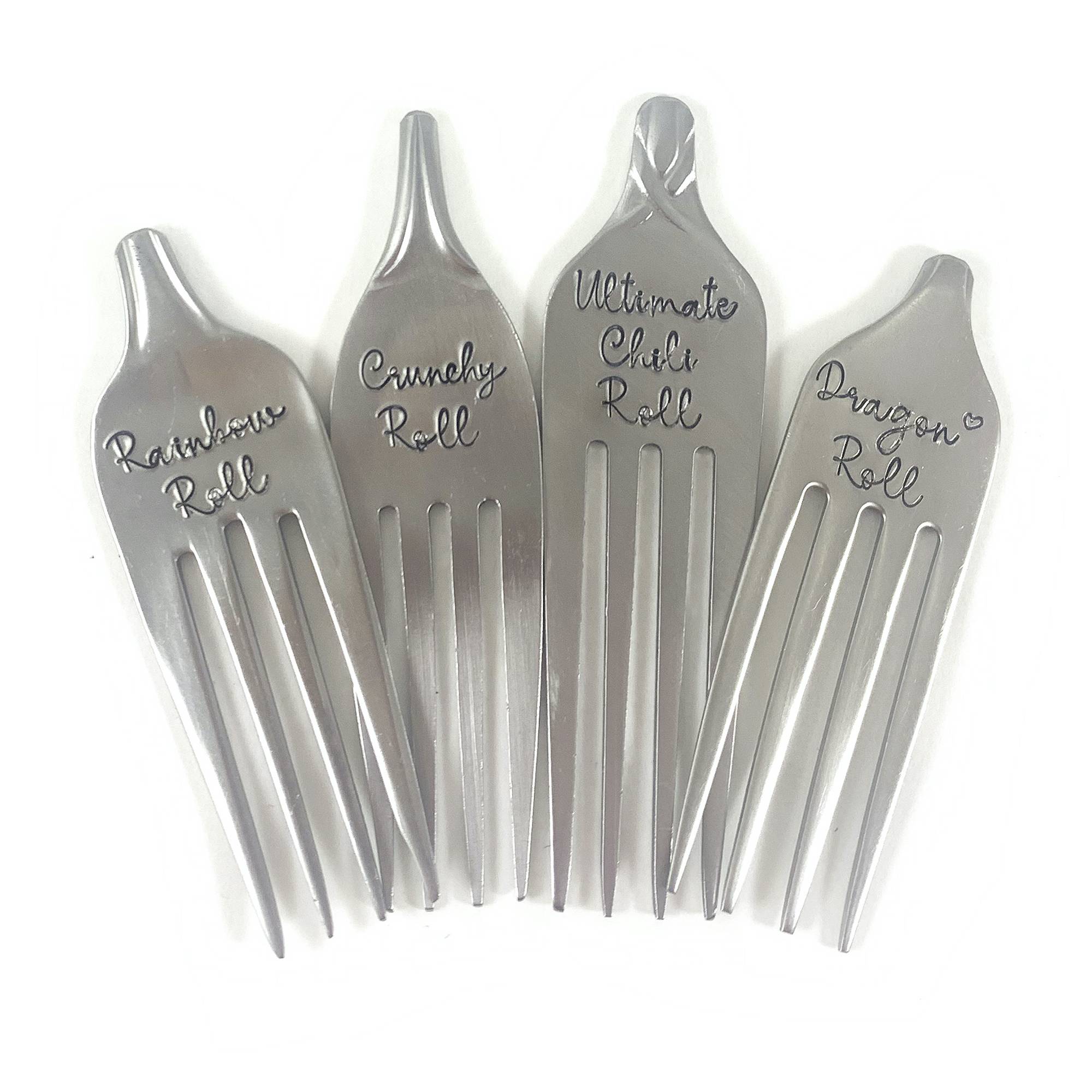 Four Unique Sushi Label Forks are displayed side by side, each engraved in a playful script with “Rainbow Roll,” “Crunchy Roll,” “Ultimate Chili Roll,” and “Dragon Roll.”. Read more at Stamping Cat Studio (stampingcatstudio.com).