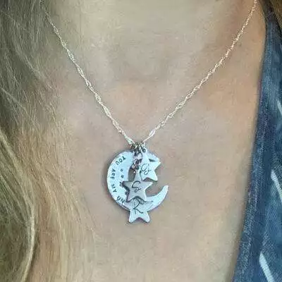 A close-up of the Moms Heavenly Moon And Stars Necklace, showing a crescent moon pendant engraved with "You are my" and three silver star charms each featuring the letters "S," "A," and "R. Read more at Stamping Cat Studio (stampingcatstudio.com).