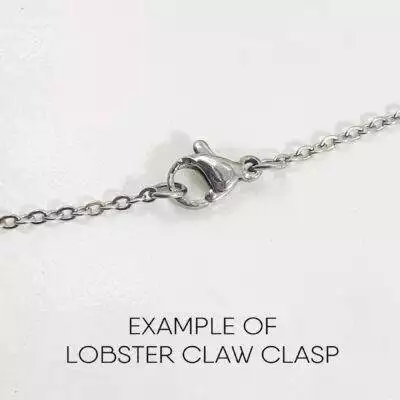 A close-up of the Dreamy Sun, Moon And Stars Necklace features an oval lobster claw clasp with a small lever in the center. Below the chain, “EXAMPLE OF LOBSTER CLAW CLASP” is written on a white background. Read more at Stamping Cat Studio (stampingcatstudio.com).