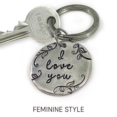 The My Love key ring feminine words is displayed: a silver key and round metal key ring engraved with "I love you" plus vine and leaf designs. The phrase "FEMININE STYLE" appears below on a white background. Read more at Stamping Cat Studio (stampingcatstudio.com).